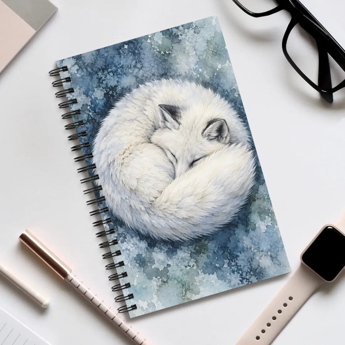 A white arctic fox sleeps curled in a circle on a blue, icy watercolor background, eyes closed – Spiral Notebook, view 2