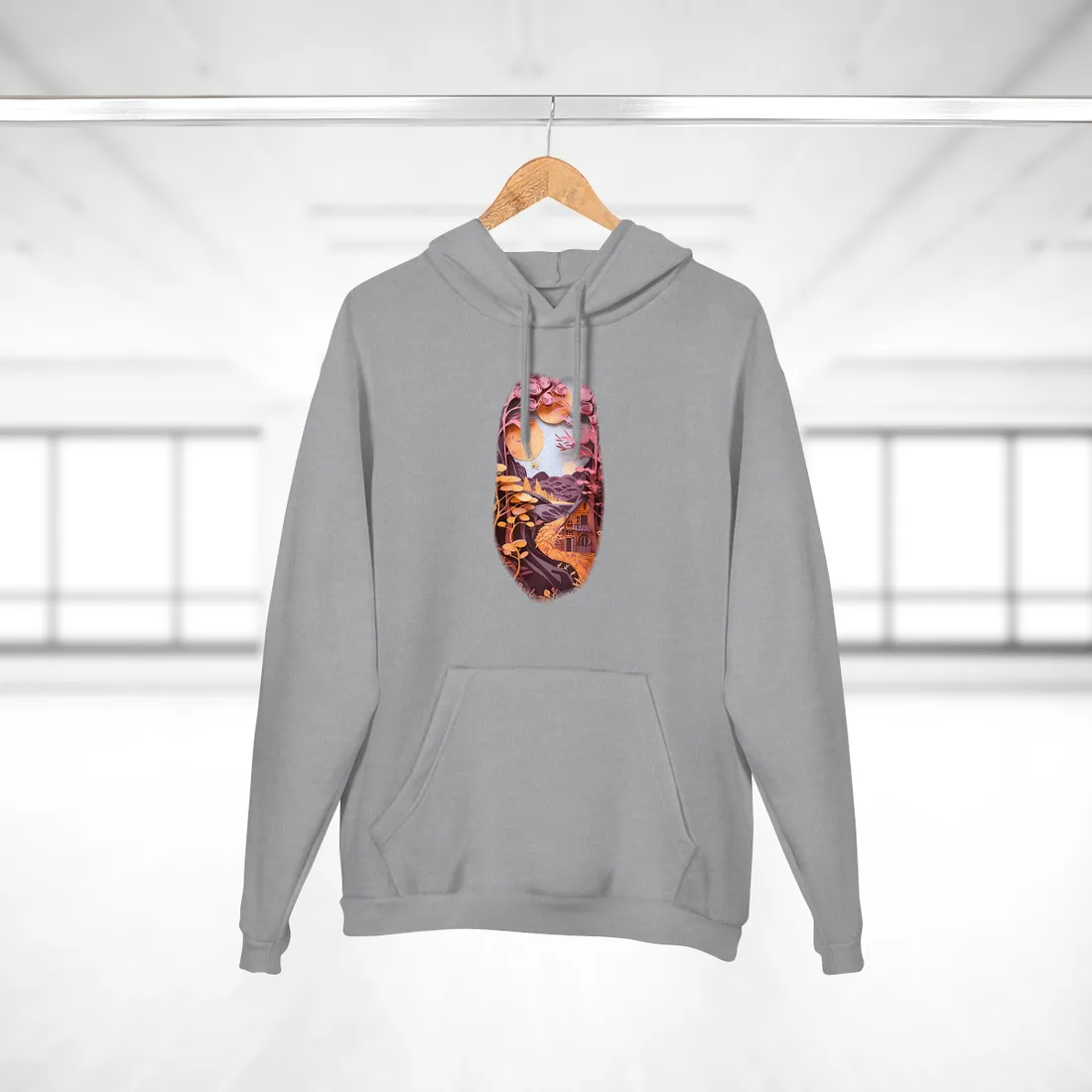 Layered paper-cut forest with pink rose-shaped trees, orange suns, a winding path, and a small house – Hoodie, heather grey