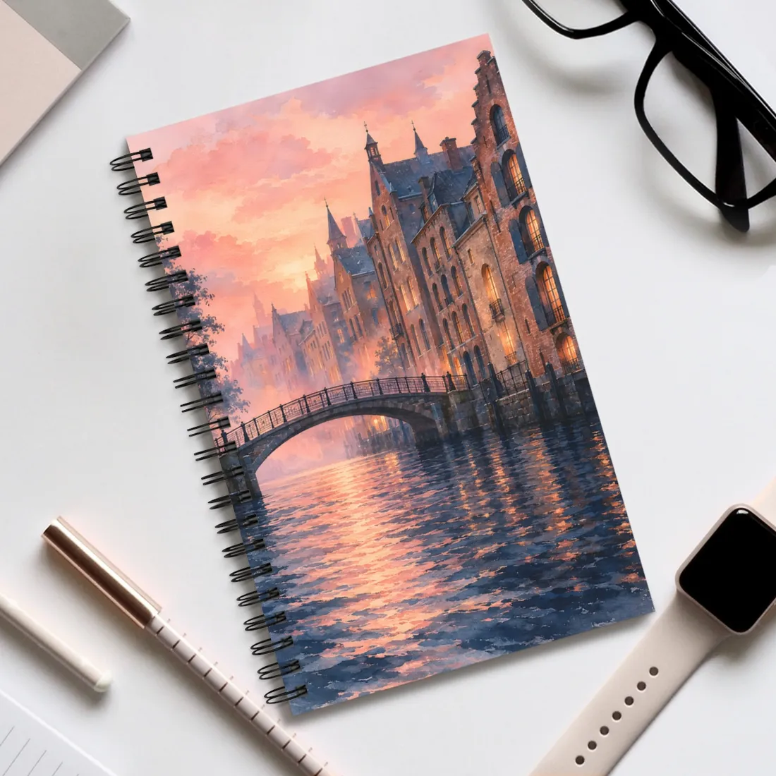 Arched footbridge over a rippling canal at sunset, with brick townhouses glowing warmly under a pin – Spiral Notebook, view 2